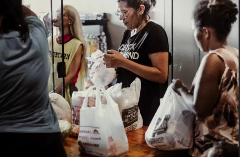 Mulher fazendo compras no mercado solidario