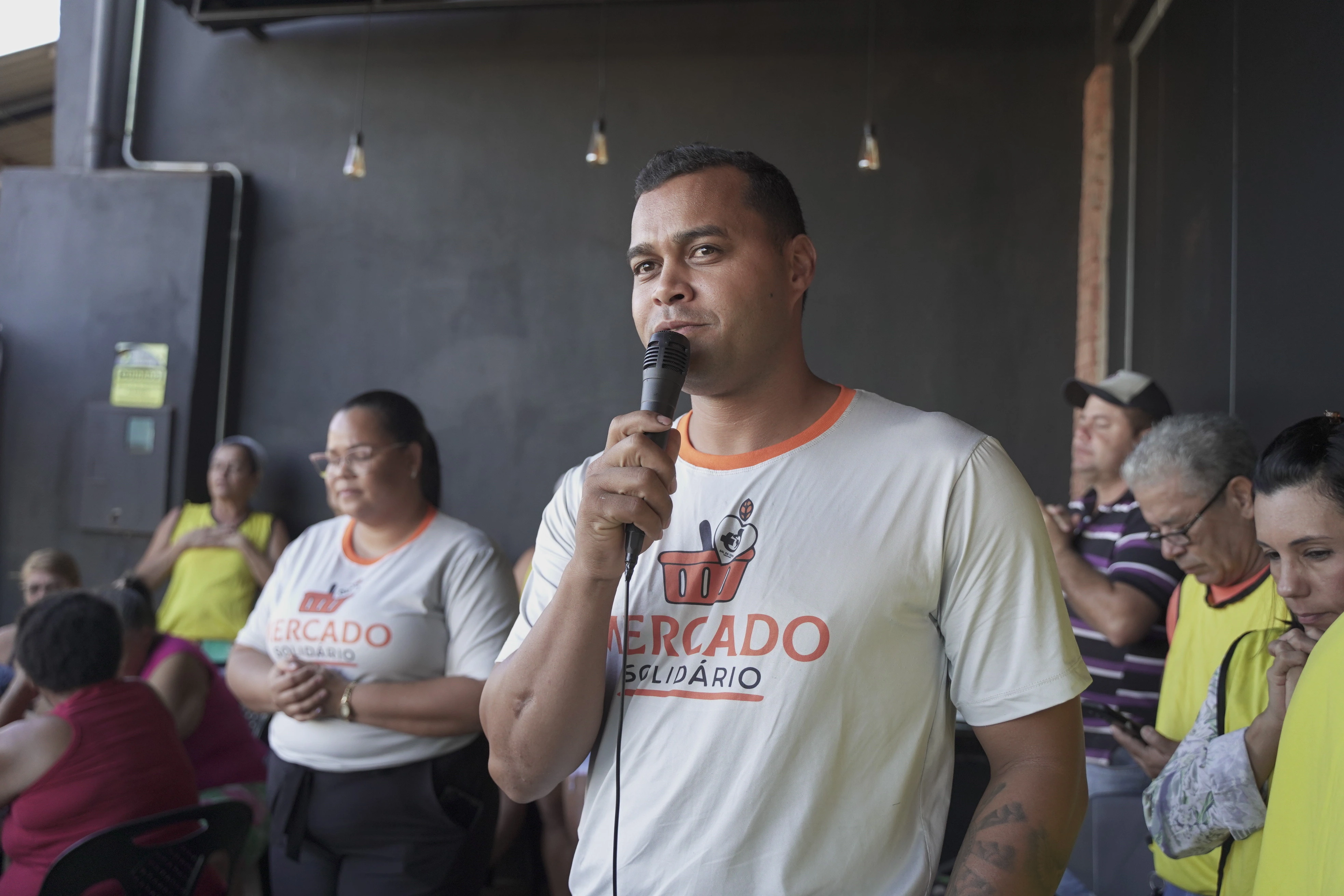 Pastor lider do mercado solidario orando pelas pessoas