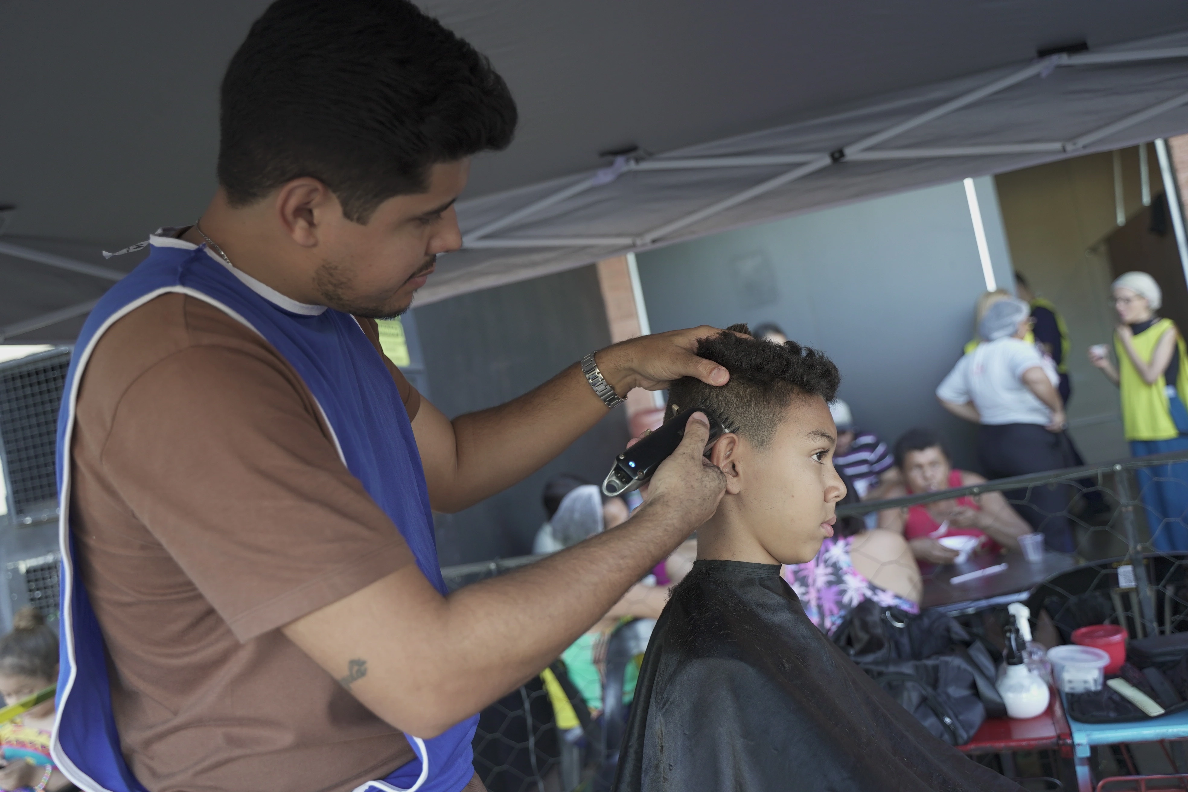 Criança cortando cabelo em projeto social da igreja